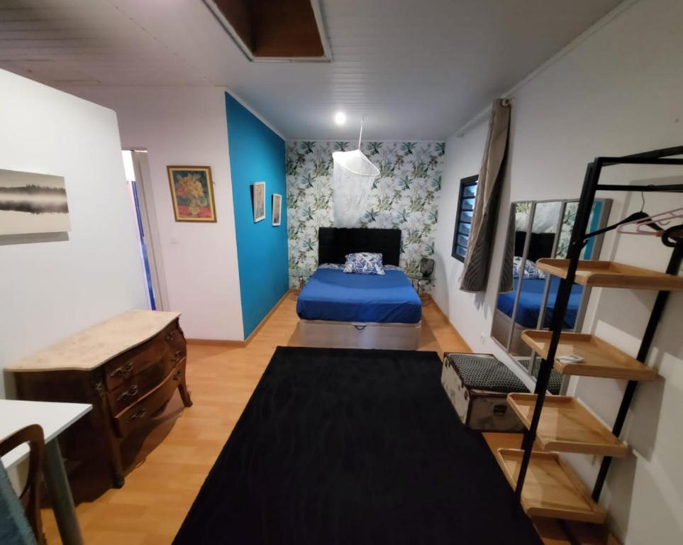um quarto com uma cama azul num quarto em Résidence L' ALAMANDA em Saint-Philippe