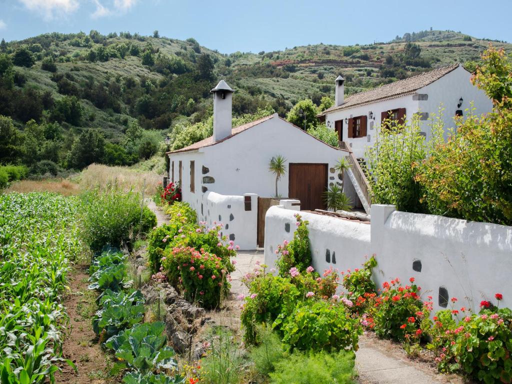 une maison avec un jardin de fleurs devant elle dans l'établissement Casa Rural La Cuna, à Los Silos