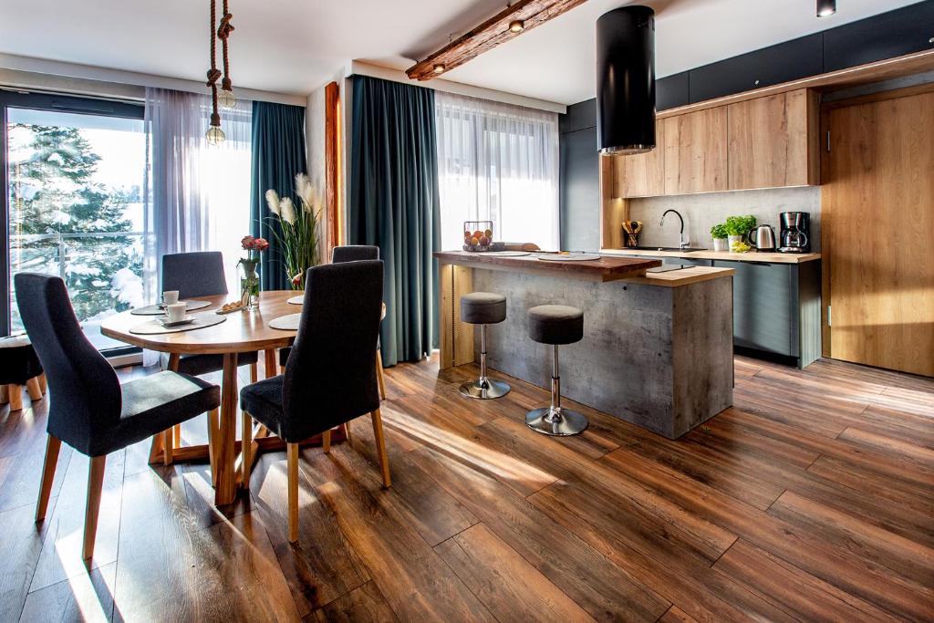 a kitchen and dining room with a table and chairs at Apartament Madlen Kalinowa Szczyrk Sauna Grota Solna in Szczyrk