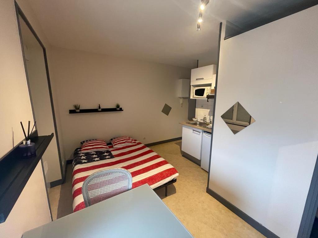 a small room with a bed and a kitchen at Studio agréable et lumineux in Niort