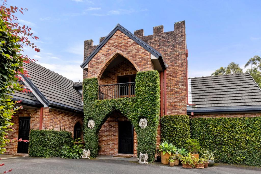 a brick building with ivy on it at The Castle at Bonville in Bonville