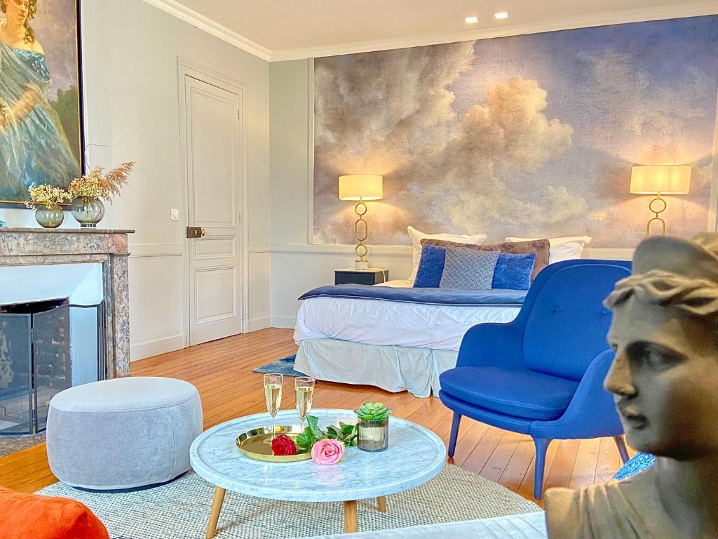 uma sala de estar com uma cama, um sofá e uma mesa em VILLA DU CEDRE Honfleur em Honfleur