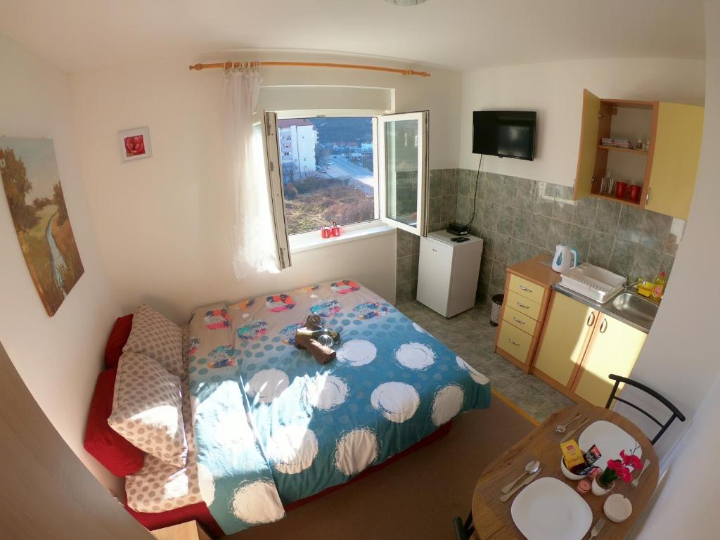 Habitación pequeña con cama y ventana en Apartman Ippon, en Police