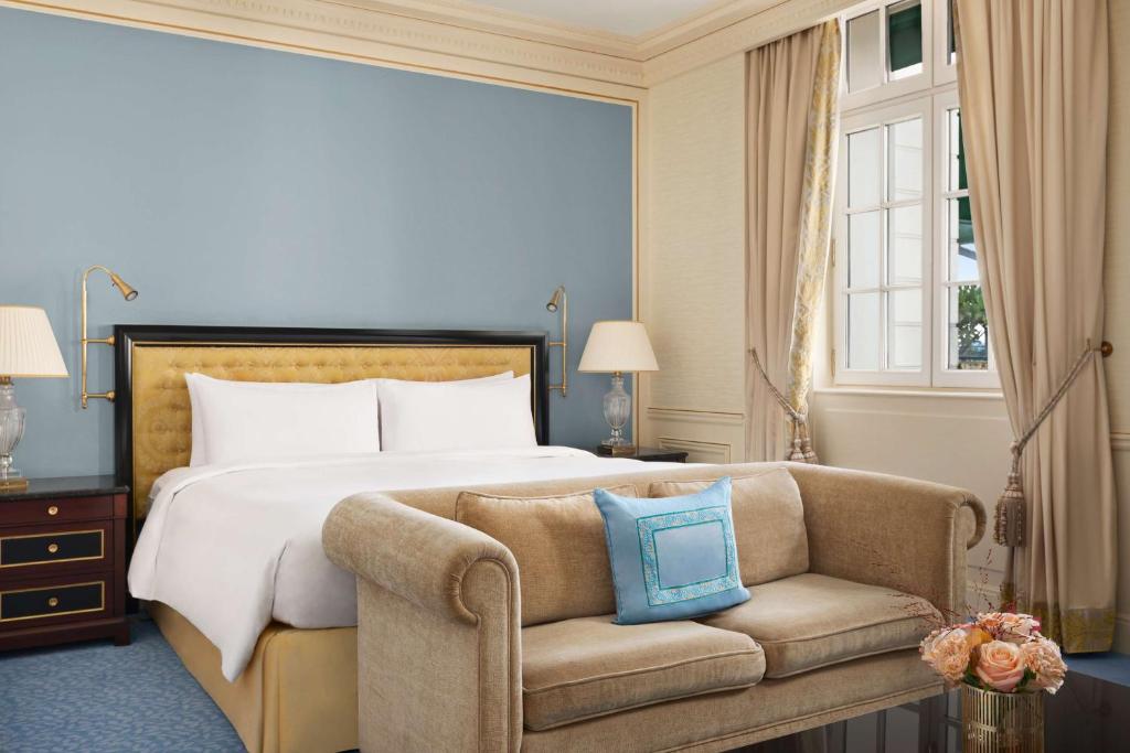 a hotel room with a bed and a couch at Shangri-La Paris in Paris