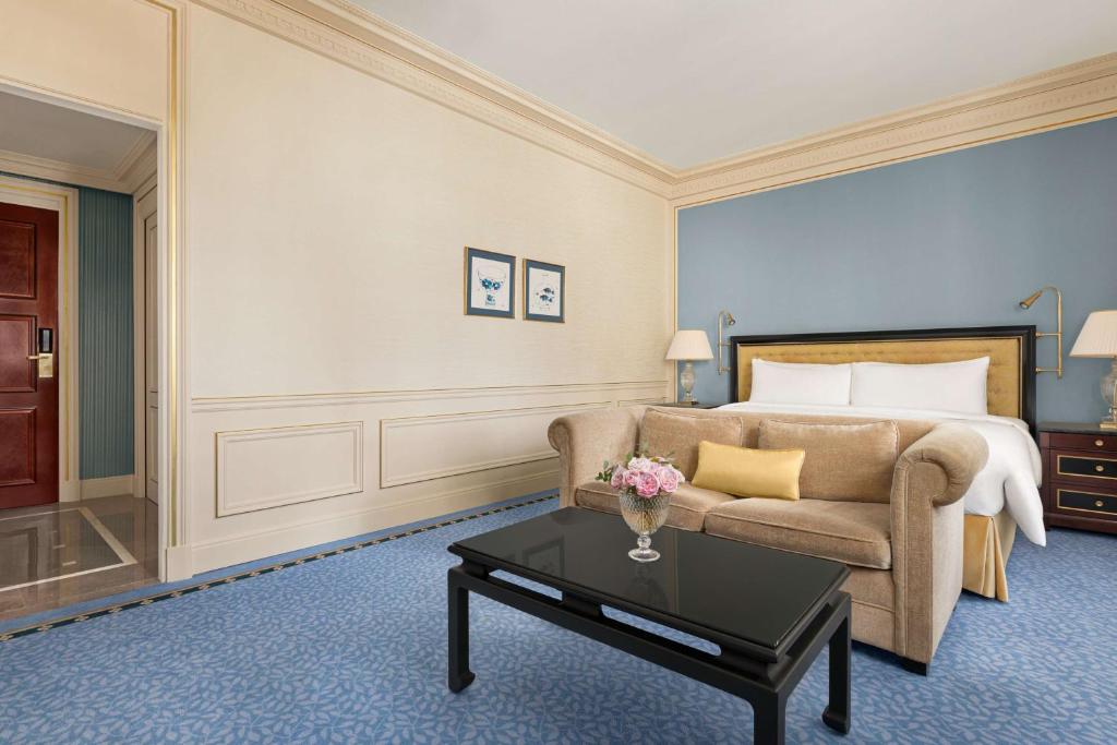 a hotel room with a bed and a couch and a table at Shangri-La Paris in Paris