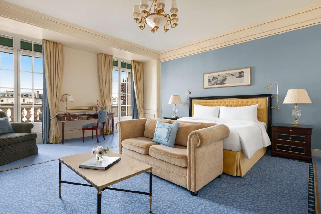 a hotel room with a bed and a couch and a chair at Shangri-La Paris in Paris