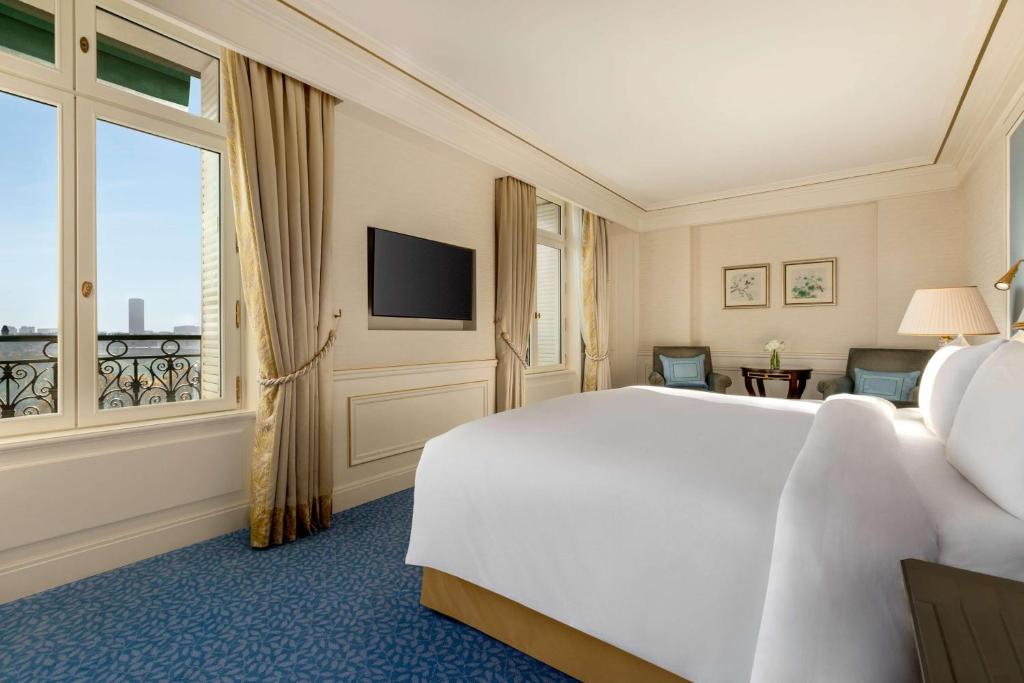 a bedroom with a large white bed and a window at Shangri-La Paris in Paris