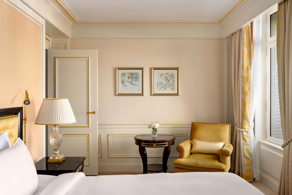 a bedroom with a bed and a chair and a table at Shangri-La Paris in Paris