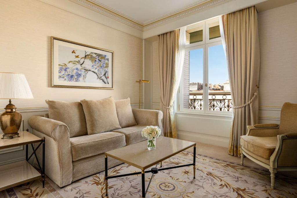 a living room with a couch and a window at Shangri-La Paris in Paris