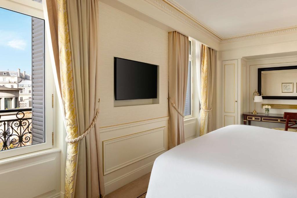a bedroom with a bed and a window at Shangri-La Paris in Paris