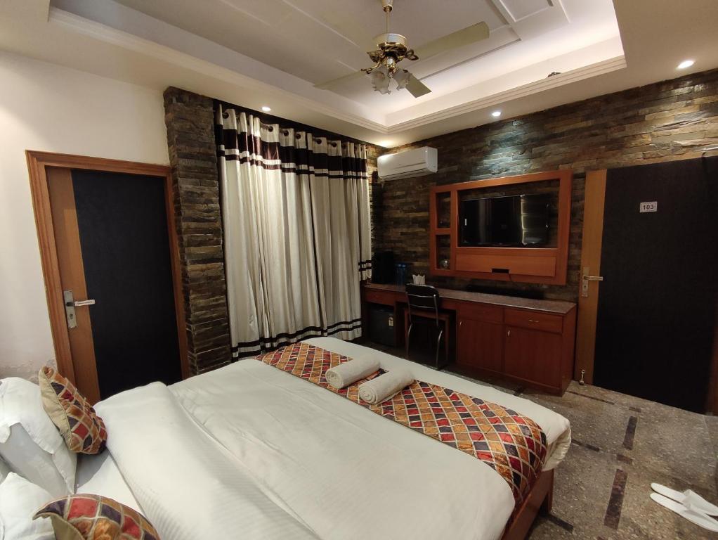 a hotel room with a bed and a television at Stay @ 203 in Noida