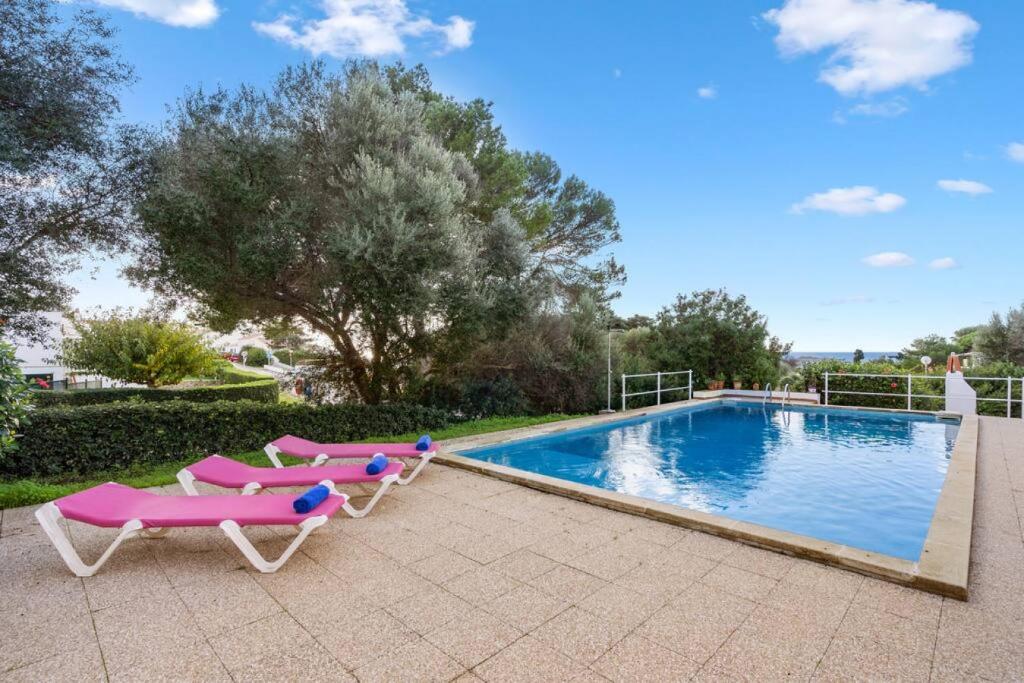 una piscina con 2 tumbonas junto a una piscina en Apartamento Cap Roig, en Binibeca