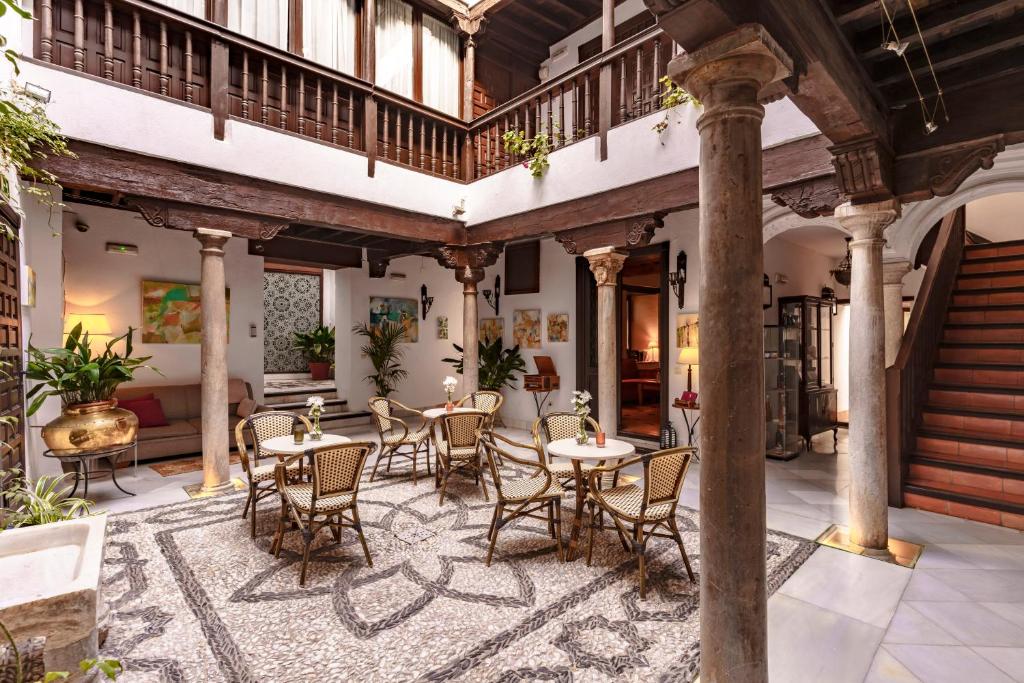 un patio interior con mesas y sillas en un edificio en Casa del Capitel Nazarí, en Granada