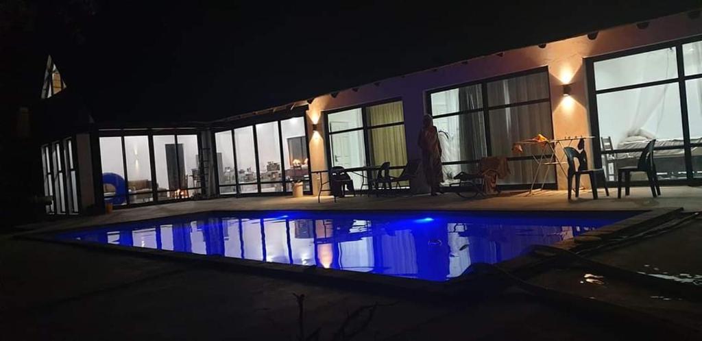 una casa con piscina por la noche en Marloth Park, Kruger safari house - solar, en Marloth Park