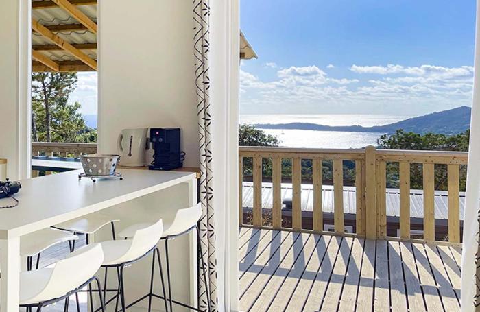 a balcony with a table and chairs on a deck at Camping Kévano Plage in Pianottoli-Caldarello