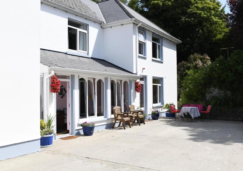 a white house with a patio in front of it at Fitzgerald's Farmhouse Accommodation in Abbeyfeale