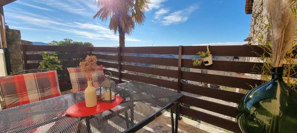 a glass table with two candles on a balcony at Jasmina Apartment in Hum