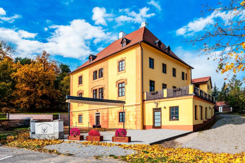 un grand bâtiment jaune avec un toit rouge dans l'établissement Vila Lovců králových, à Český Krumlov