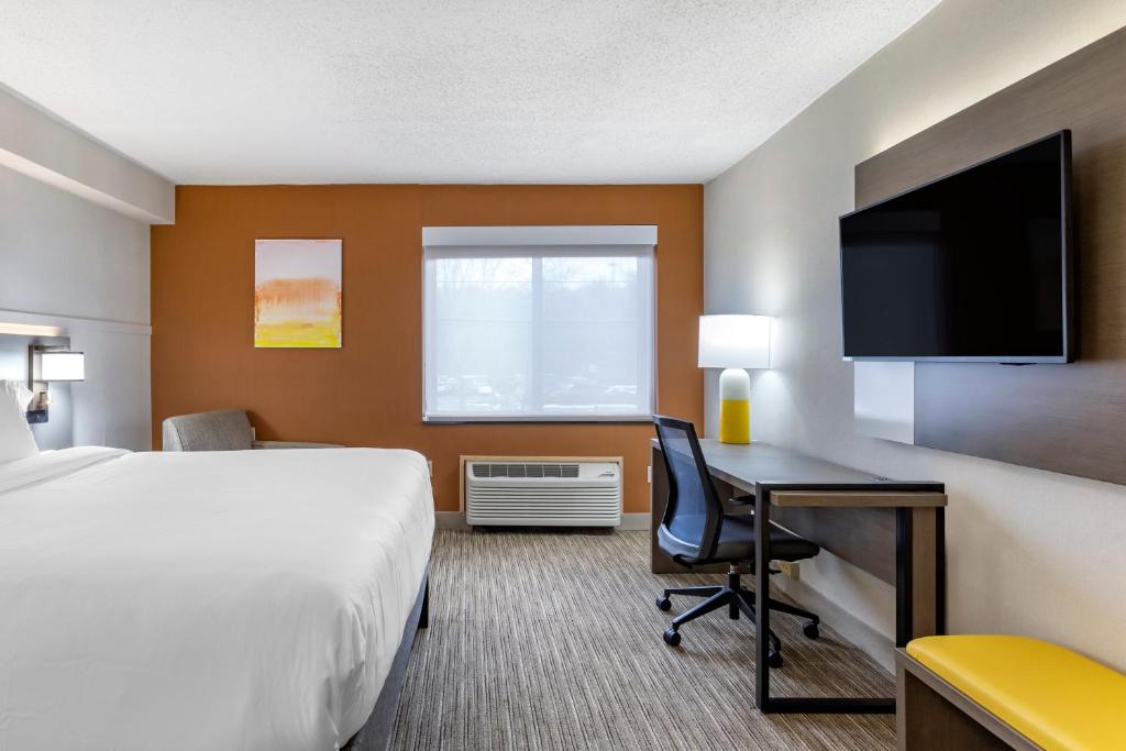 a hotel room with a bed and a desk and a tv at Comfort Inn Paramus - Hackensack in Paramus