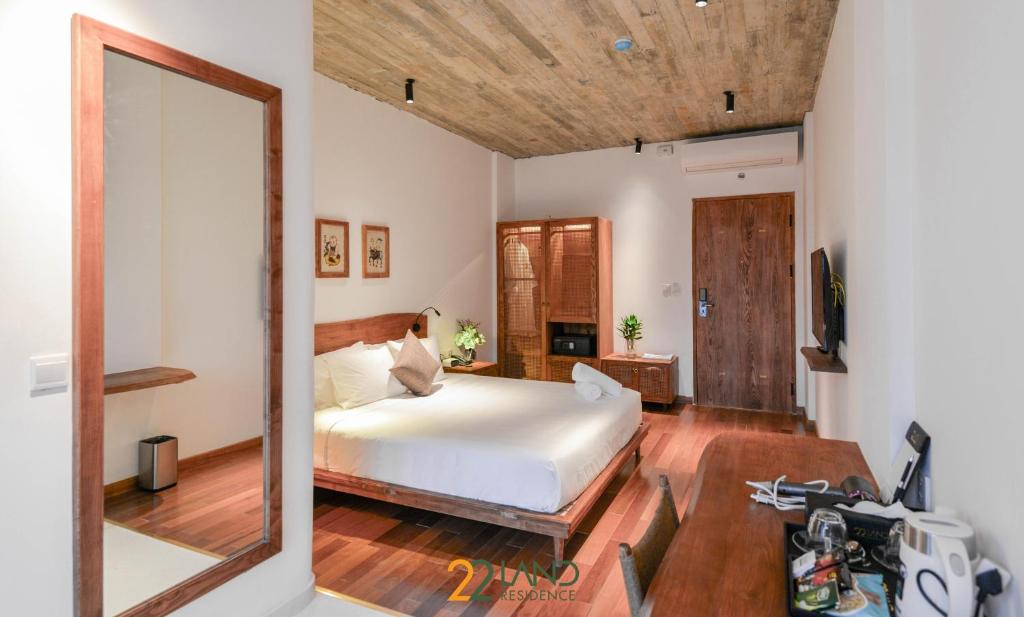 a bedroom with a bed and a large mirror at 22Land Hotel & Residence in Hanoi