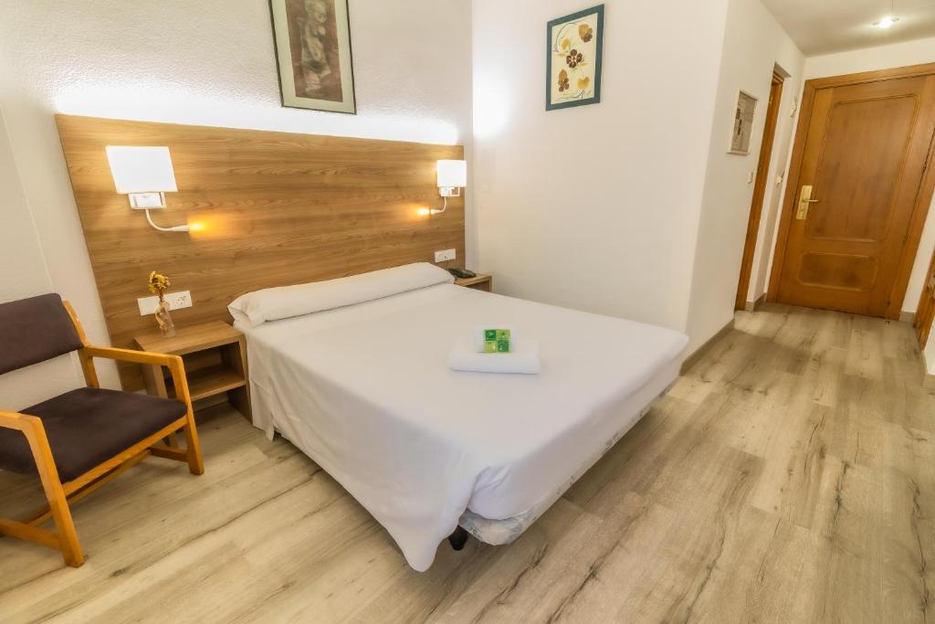 een slaapkamer met een groot wit bed en een stoel bij Pacoche Murcia in Murcia