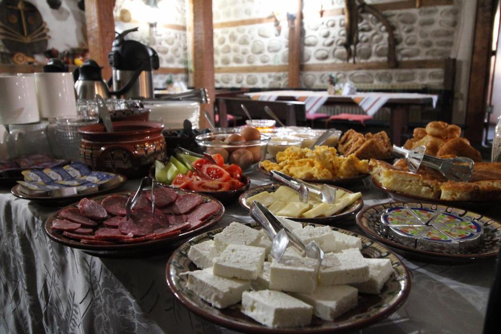 Une table avec de nombreux types différents de denrées alimentaires dans l'établissement Старата Тонина къща, à Dobrinichte