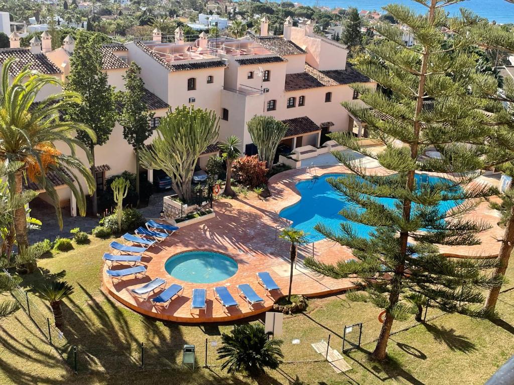 an aerial view of a resort with a swimming pool and chairs at Apartamentos El Toro in Marbella