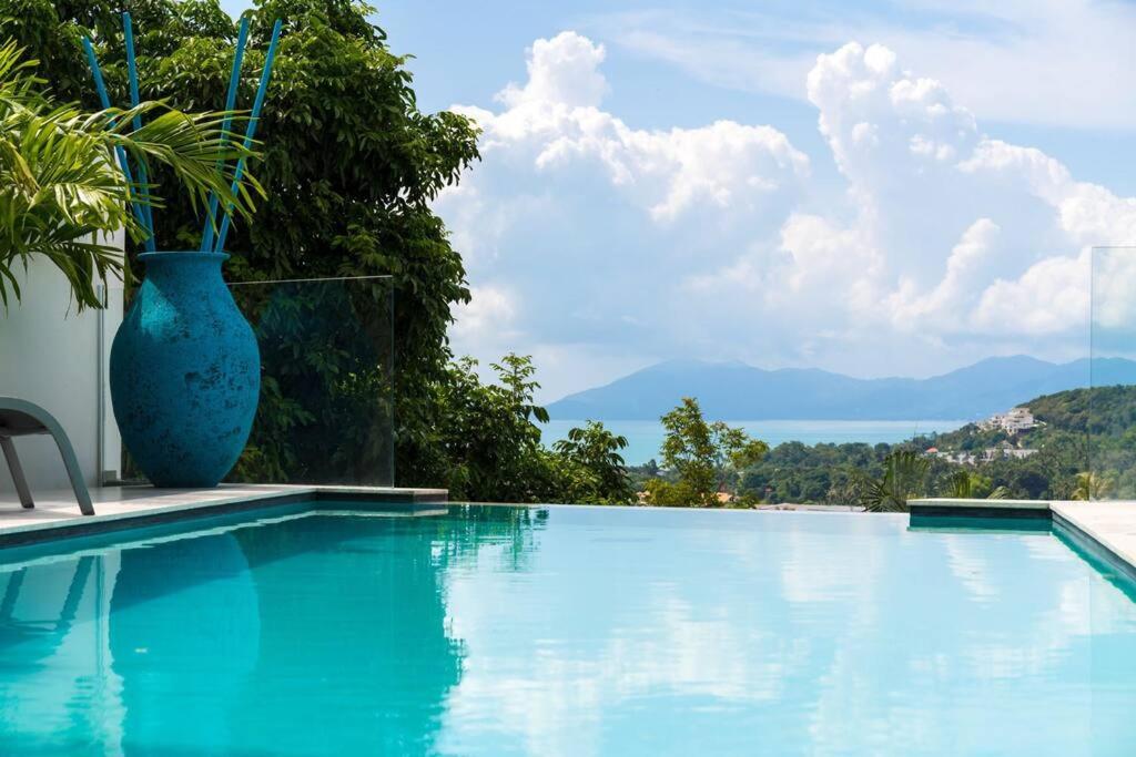 um grande vaso azul sentado ao lado de uma piscina em Villa SUAY - 2 swimming pool and SEA VIEW by VILLA FOR YOU em Koh Samui