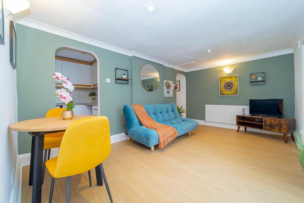 a living room with a blue couch and a table at NEXT TO BRIGHTON SEAFRONT I TWO BED ROOM FLAT WITH OUTSIDE SPACE in Brighton & Hove