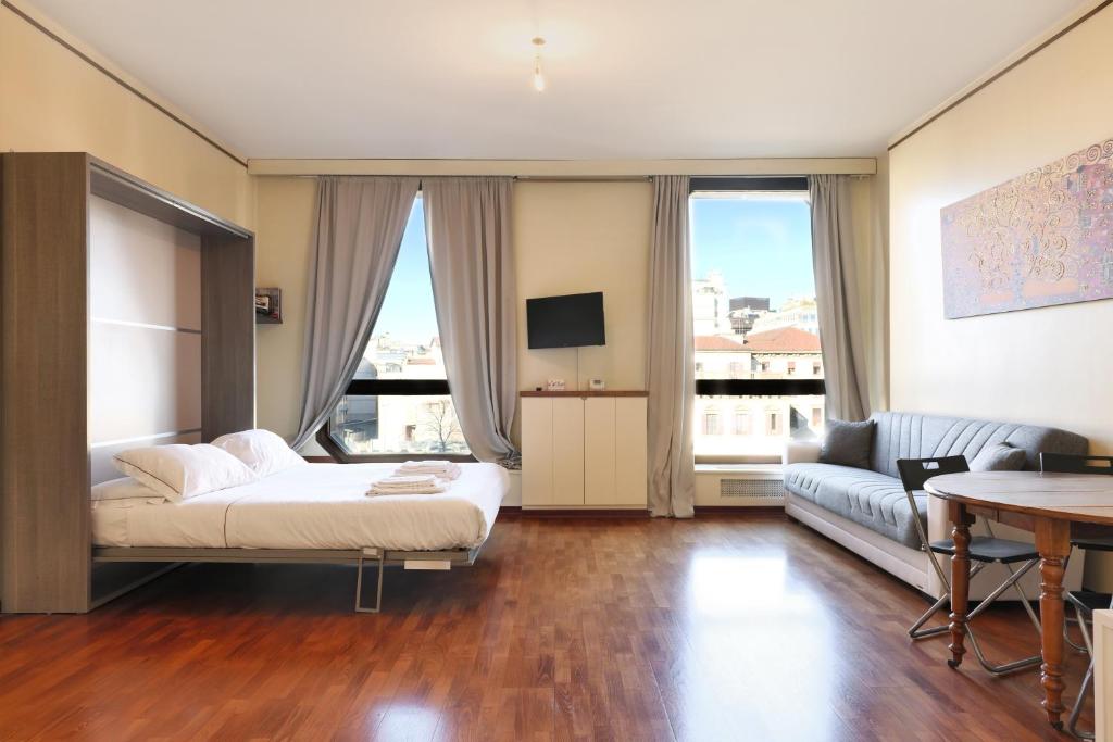 een woonkamer met een bed en een bank bij Duomo Luxury Apartment VII in Milaan