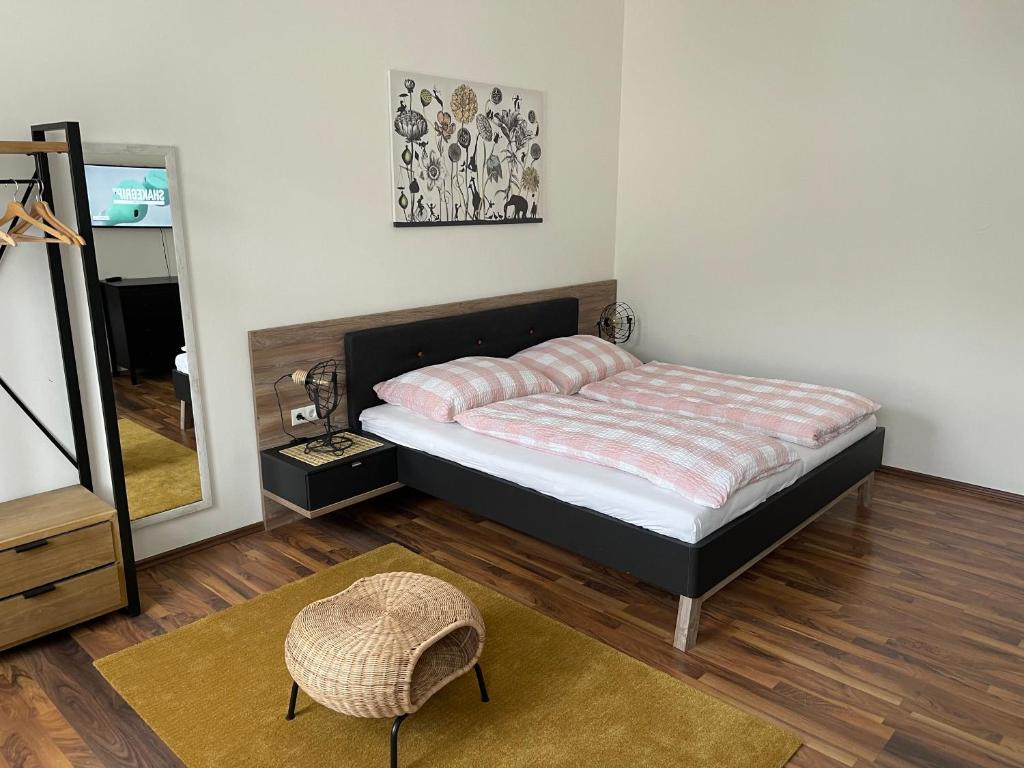 een slaapkamer met een bed, een spiegel en een kruk bij Gesamte Unterkunft in Zentrumsnähe in Wenen