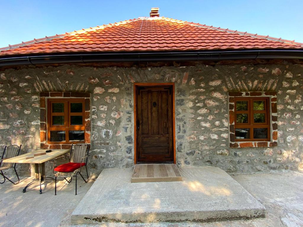 a stone house with a table and a wooden door at Apartment Old House in Podgorica