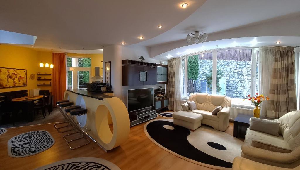 un soggiorno con divano, sedie e TV di Marble Villa: Luxury estate - central but intimate a Sinaia