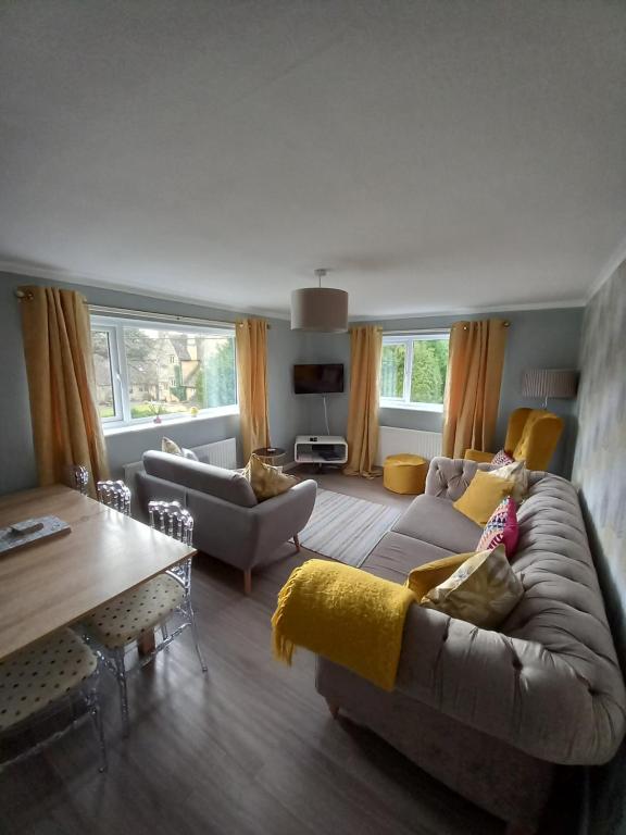 ein Wohnzimmer mit einem Sofa und einem Tisch in der Unterkunft Moore Apartment in Bourton on the Water