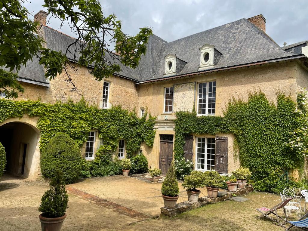 a large brick house with plants and trees at Clos Saint Léonard in Durtal
