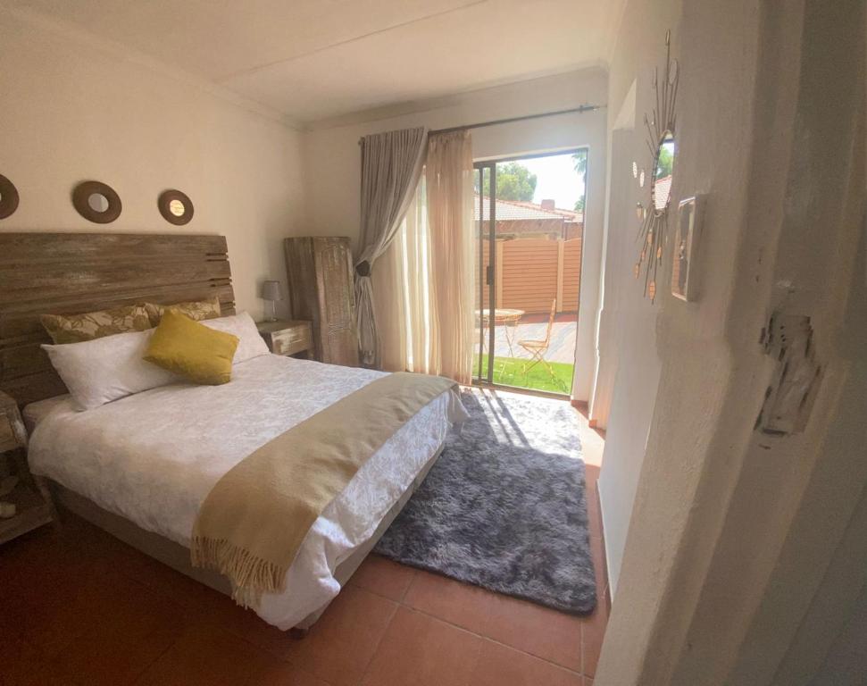 sypialnia z łóżkiem i przesuwnymi szklanymi drzwiami w obiekcie Lime Court One w mieście Pretoria