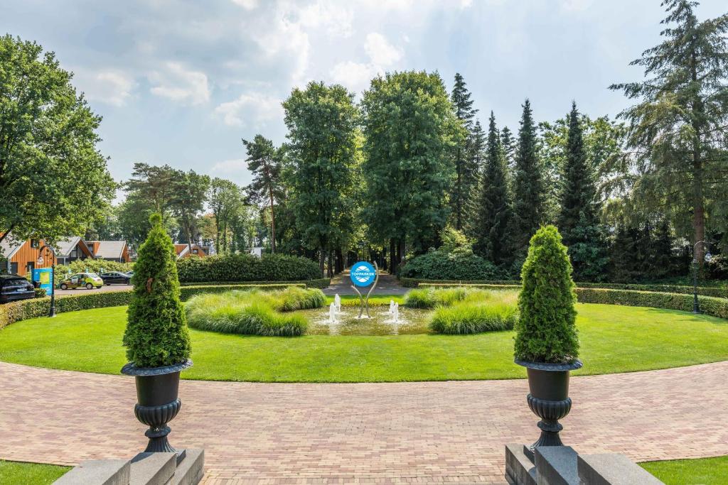 un jardín con una fuente y árboles en un parque en TopParken – Landgoed de Scheleberg, en Lunteren