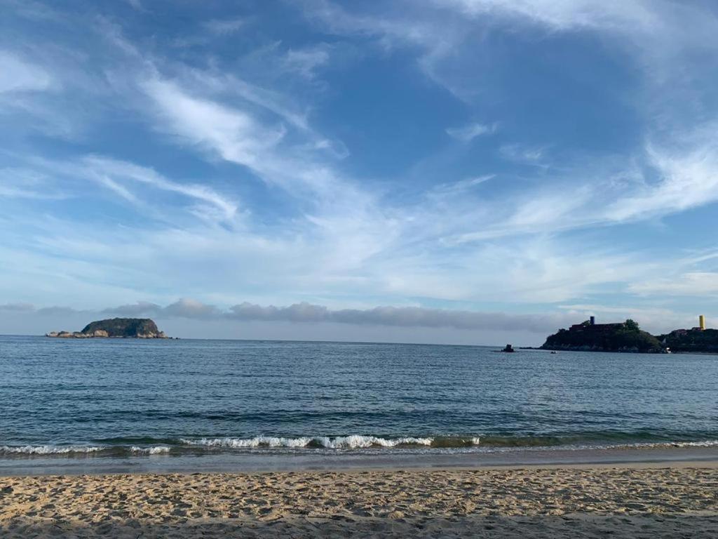 a view of the ocean with islands in the distance at Paradise Huatulco Condo TANGOLUNDA BEACH in Tangolunda