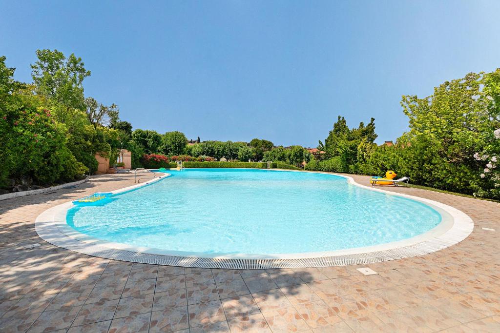 a large swimming pool on a brick patio at Residence Edera 18 by Wonderful Italy in Polpenazze del Garda