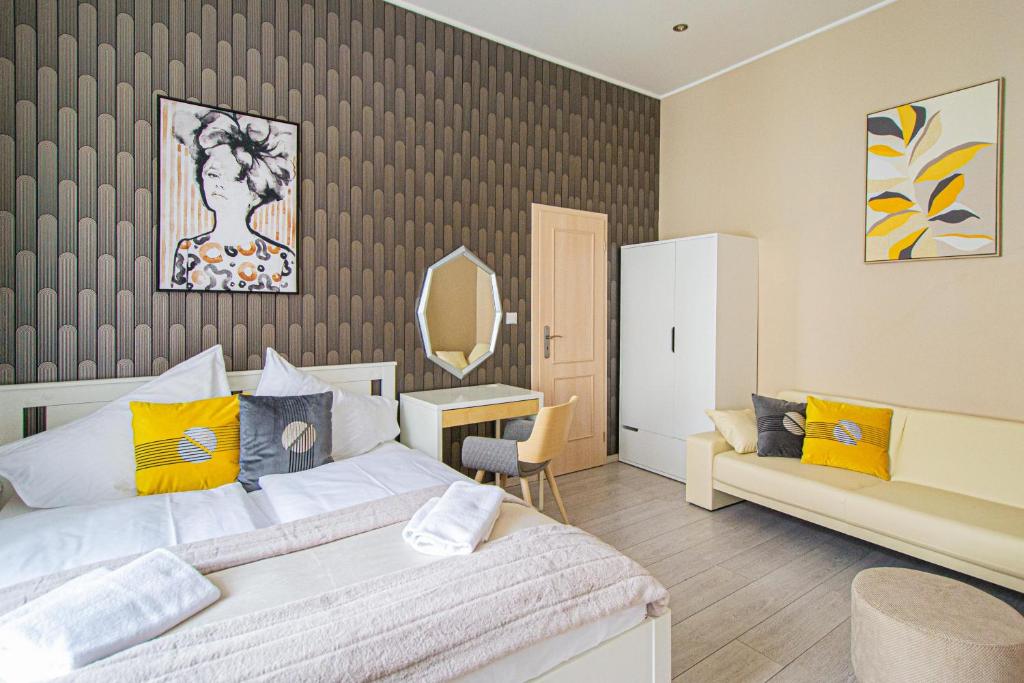 a bedroom with a bed and a couch and a mirror at Ruterra Apartment Charles Bridge in Prague