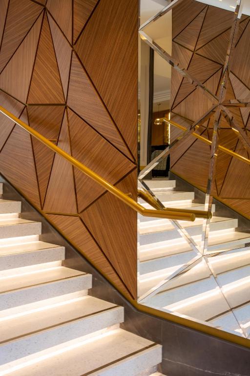 a spiral staircase with a wooden wall and wooden stairsythonythonythonythonythonython at Hôtel Apollinaire Nice in Nice