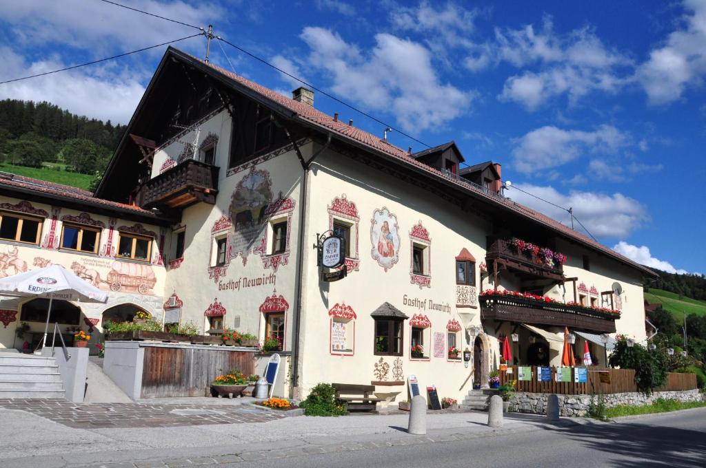 un grande edificio bianco con tetto nero di Gasthof Neuwirt a Ellbögen