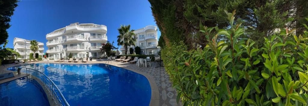 a hotel with a swimming pool in front of a building at BELKA GOLF RESİDENCE Poolside apt1 Belek in Belek