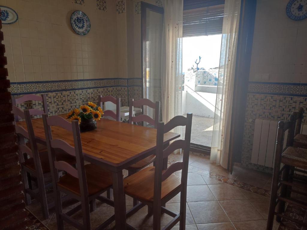 CASA ALBA E IRENE في بوبيون: طاولة طعام وكراسي عليها إناء ورد