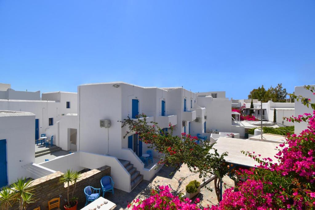 a view of a town with white buildings and pink flowers at Ayeri Hotel in Parikia