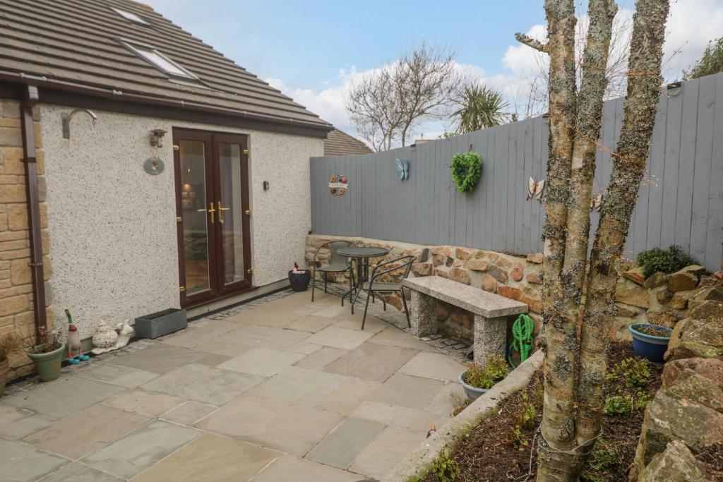 a patio with a stone bench and a table at Pippas place in Penzance