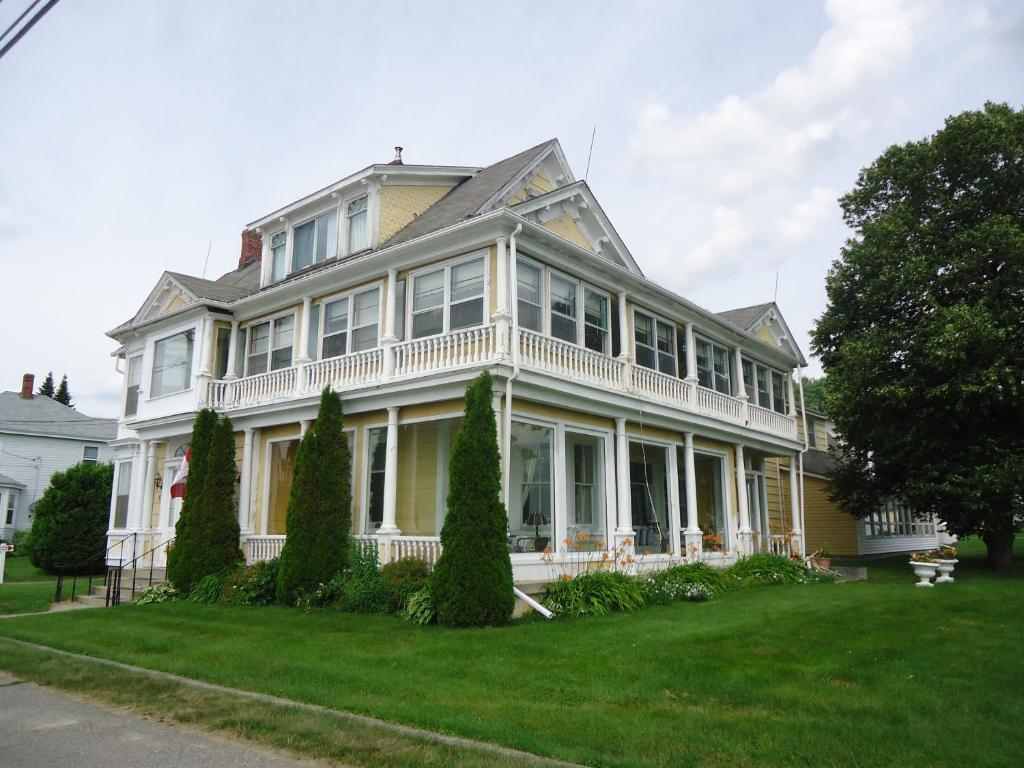 Casa blanca grande con porche blanco en Governor's Mansion Inn, en Miramichi