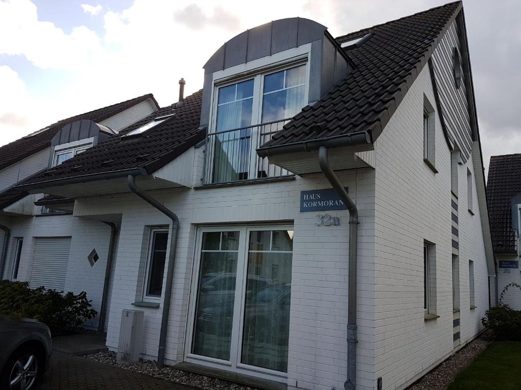 Cette maison blanche dispose d'une grande fenêtre. dans l'établissement Darßer Weg 32a "Kormoran" Wohnung 16, à Zingst
