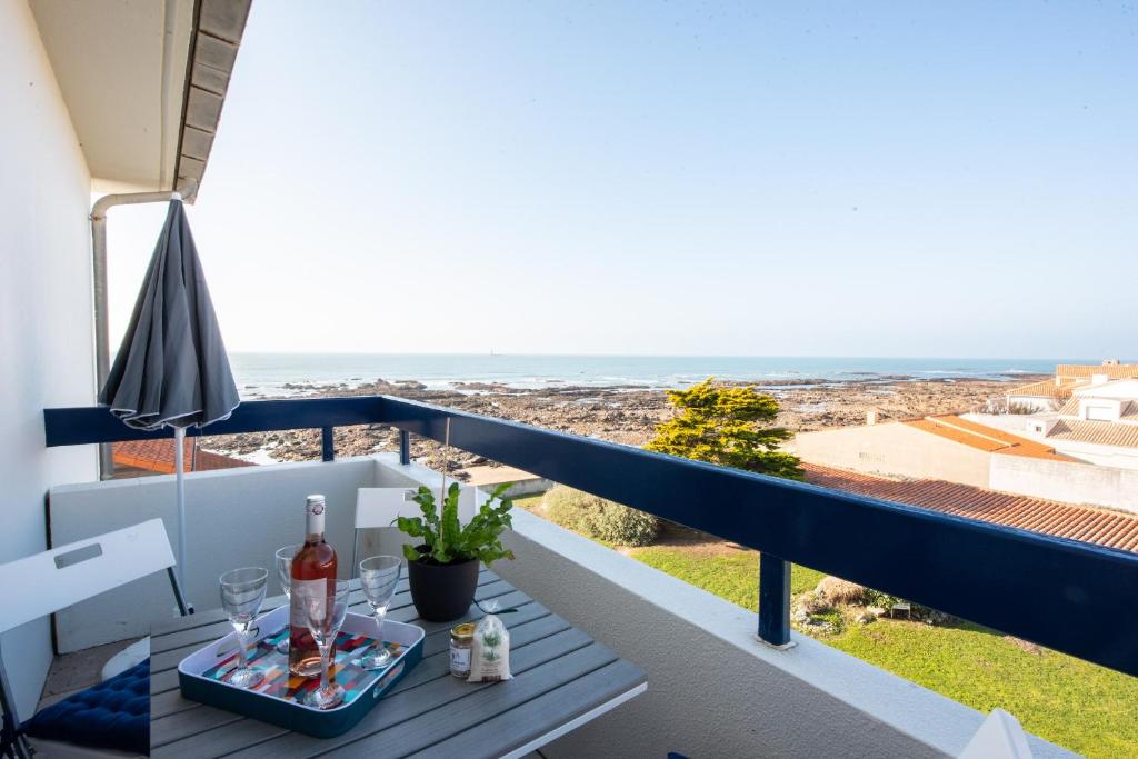 uma mesa numa varanda com vista para o oceano em Charmant appartement avec vue imprenable sur la mer em Les Sables-dʼOlonne