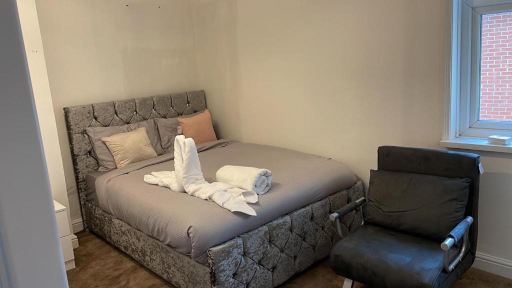 1 cama con toallas en una habitación con silla en Alder en-suite self catering with private shower 3, en Southampton